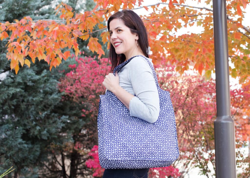 Person with branded bag enjoying autumn day with fall-colored leaves